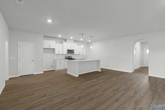 kitchen with white cabinets, appliances with stainless steel finishes, open floor plan, recessed lighting, and an island with sink