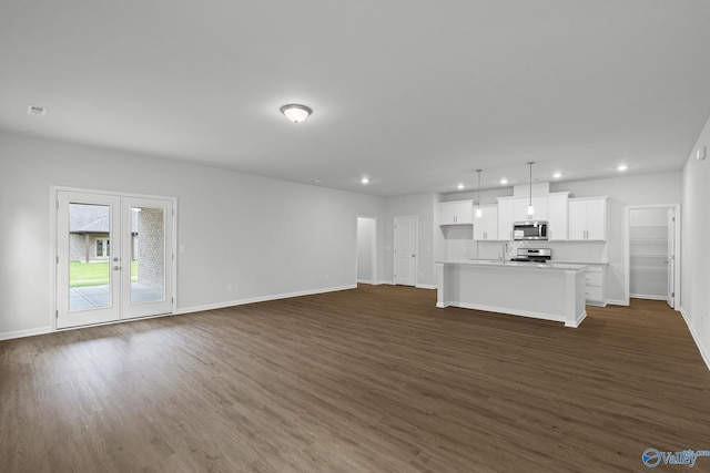 unfurnished living room featuring recessed lighting, dark wood-style floors, and baseboards