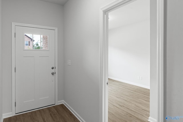 foyer featuring baseboards and dark wood-type flooring
