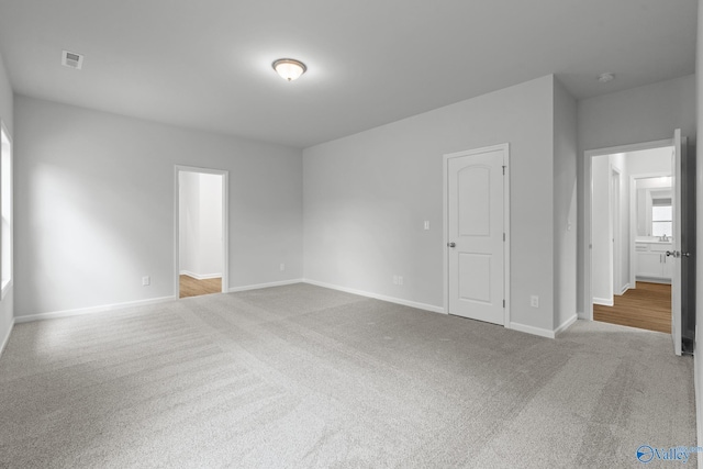 spare room with visible vents, carpet floors, and baseboards