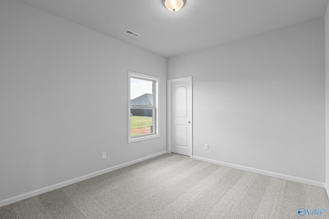 carpeted spare room with visible vents and baseboards