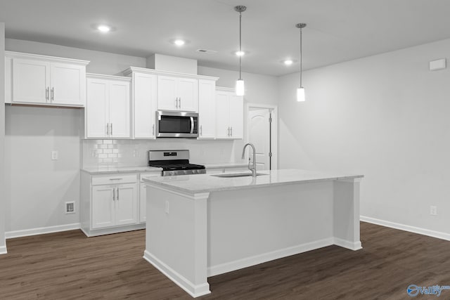 kitchen featuring a sink, stainless steel appliances, tasteful backsplash, white cabinetry, and dark wood finished floors