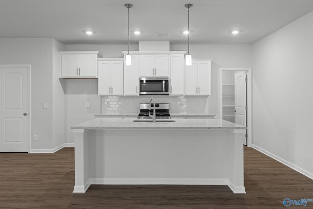 kitchen with appliances with stainless steel finishes, white cabinetry, a kitchen island with sink, and a sink