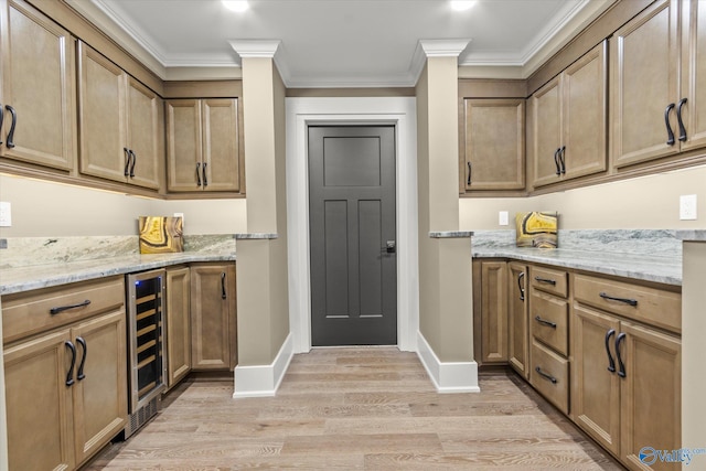 interior space with crown molding, beverage cooler, light stone counters, and light hardwood / wood-style flooring