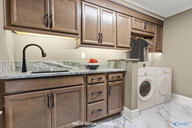 laundry area with cabinets, sink, ornamental molding, and independent washer and dryer