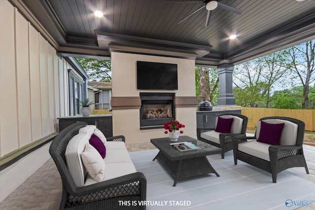 view of patio / terrace featuring ceiling fan and an outdoor living space with a fireplace