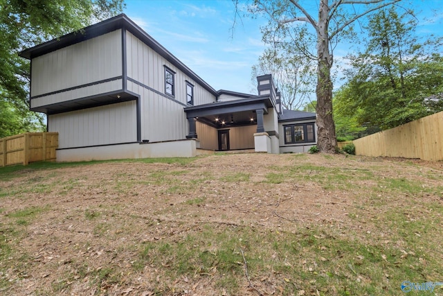 back of house featuring a lawn