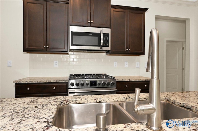5 Leyland Dr, Huntsville, AL 35824 - kitchen with appliances with stainless steel finishes, backsplash, dark brown cabinetry, ornamental molding, and light stone countertops