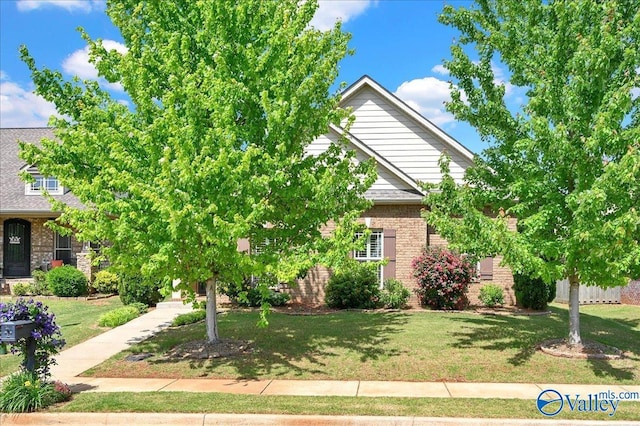 5 Leyland Dr, Huntsville, AL 35824 - view of property hidden behind natural elements featuring brick siding, a front yard, and roof with shingles