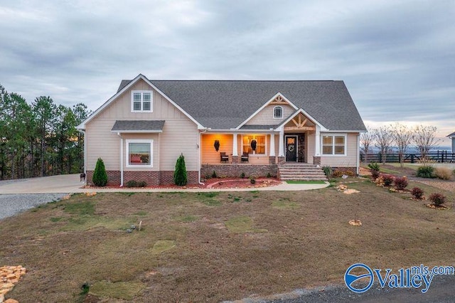 craftsman inspired home with covered porch and a front yard