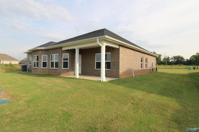 view of front of property with a patio, a front yard, and central air condition unit