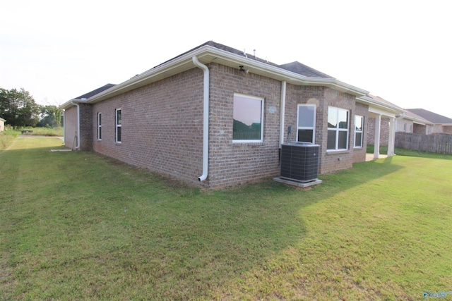 view of side of property with a lawn and central air condition unit