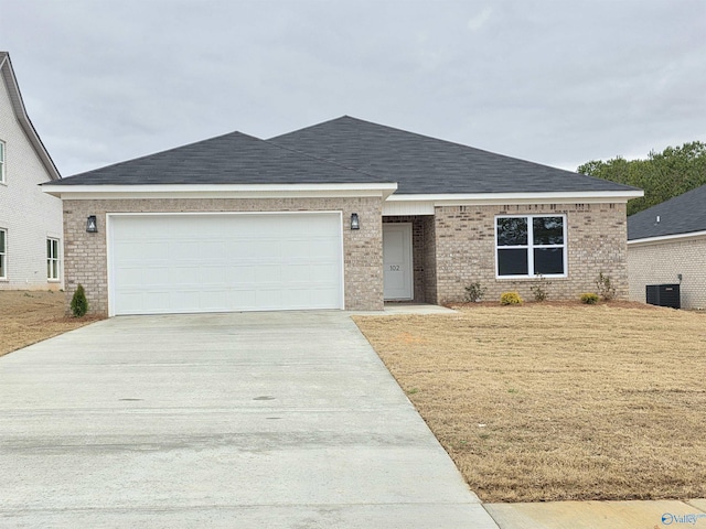 ranch-style home with brick siding, driveway, a garage, and roof with shingles