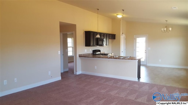 kitchen featuring a peninsula, black microwave, range, and a wealth of natural light