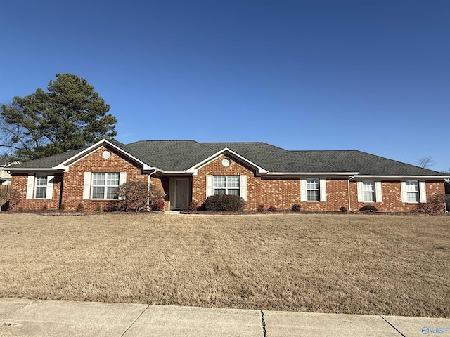 ranch-style house featuring a front lawn, roof with shingles, and brick siding