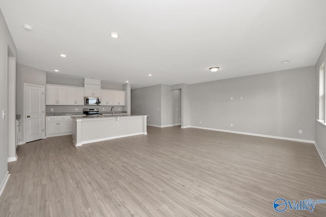 unfurnished living room with sink and light hardwood / wood-style flooring