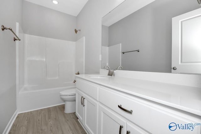 full bathroom featuring toilet, hardwood / wood-style floors, vanity, and shower / bath combination