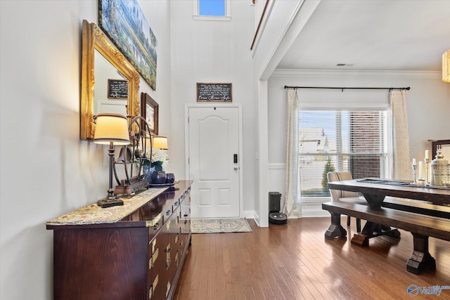 entrance foyer featuring dark wood-style floors, baseboards, and crown molding