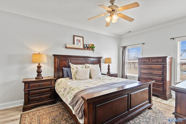 bedroom with ornamental molding, ceiling fan, light wood finished floors, and baseboards