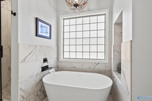 full bathroom featuring a shower, a notable chandelier, a freestanding bath, and tile walls