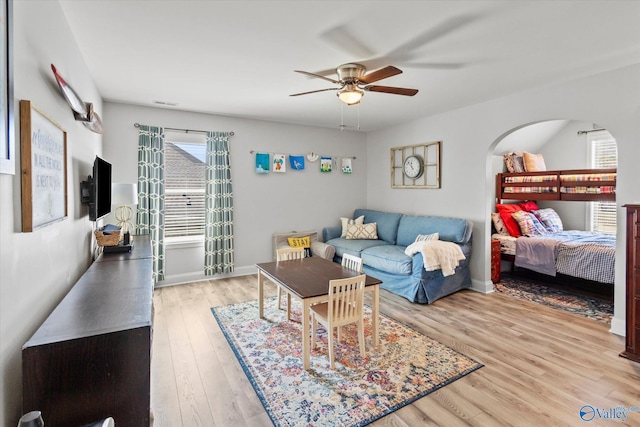 living room with visible vents, wood finished floors, a ceiling fan, and baseboards