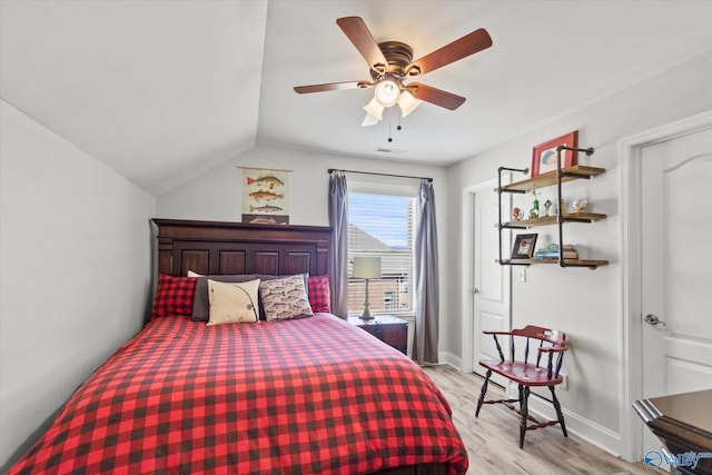 bedroom with vaulted ceiling, baseboards, light wood-style flooring, and a ceiling fan