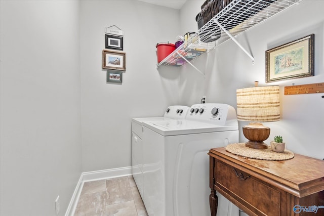 clothes washing area featuring baseboards, laundry area, and washer and dryer