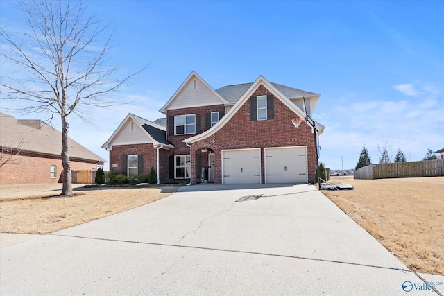 view of front of house with a garage, brick siding, driveway, and fence