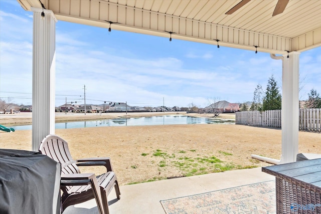 view of patio / terrace with a water view, fence, and an outdoor pool