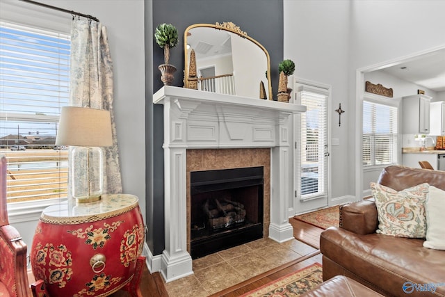 living room featuring tile patterned flooring, a fireplace, and baseboards