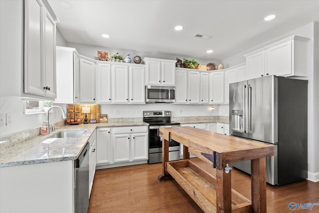 kitchen featuring visible vents, appliances with stainless steel finishes, dark wood-type flooring, and a sink