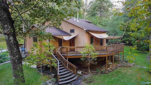 rear view of property with a deck and a lawn