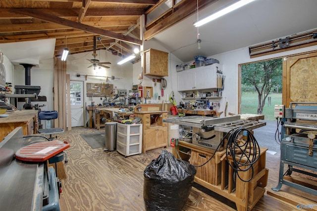 kitchen with beam ceiling, a wood stove, high vaulted ceiling, light hardwood / wood-style floors, and ceiling fan