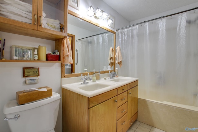 bathroom featuring vanity, toilet, tile patterned floors, and a textured ceiling