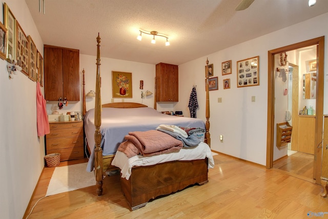 bedroom featuring ceiling fan, a textured ceiling, and light wood-type flooring