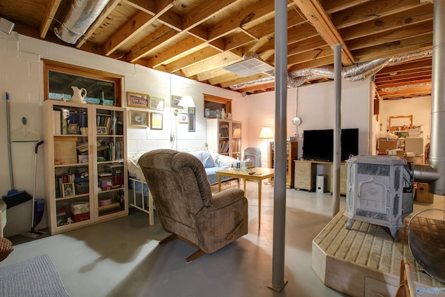 living room featuring concrete floors and a wood stove