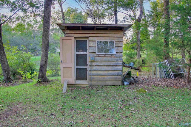 view of outbuilding featuring a lawn