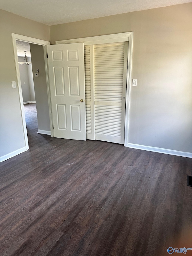 unfurnished bedroom featuring dark hardwood / wood-style floors and a closet