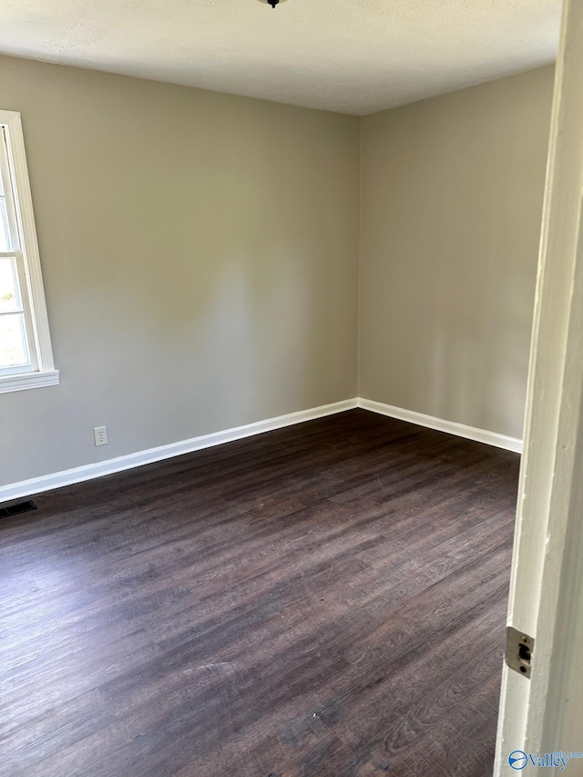 spare room featuring dark hardwood / wood-style flooring