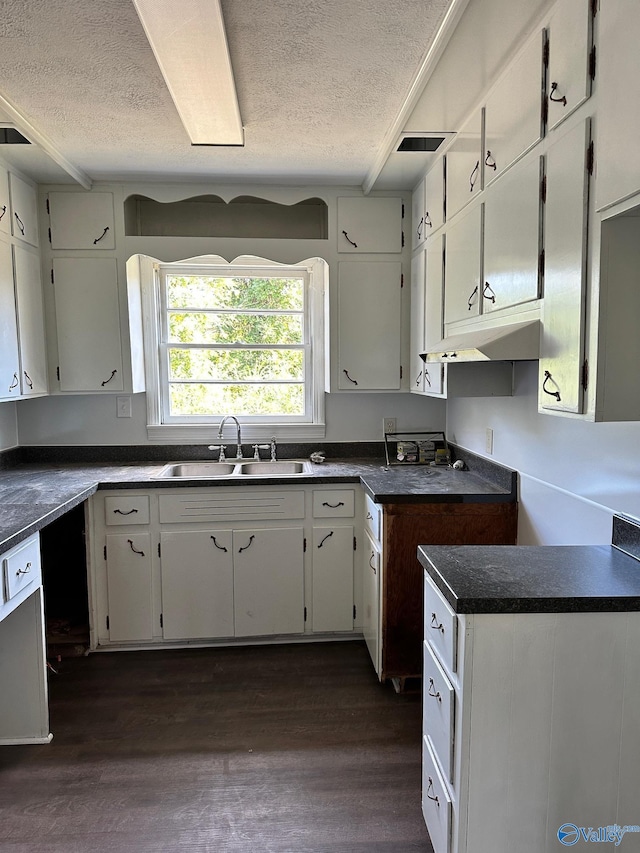 kitchen featuring a textured ceiling, dark hardwood / wood-style flooring, and white cabinetry