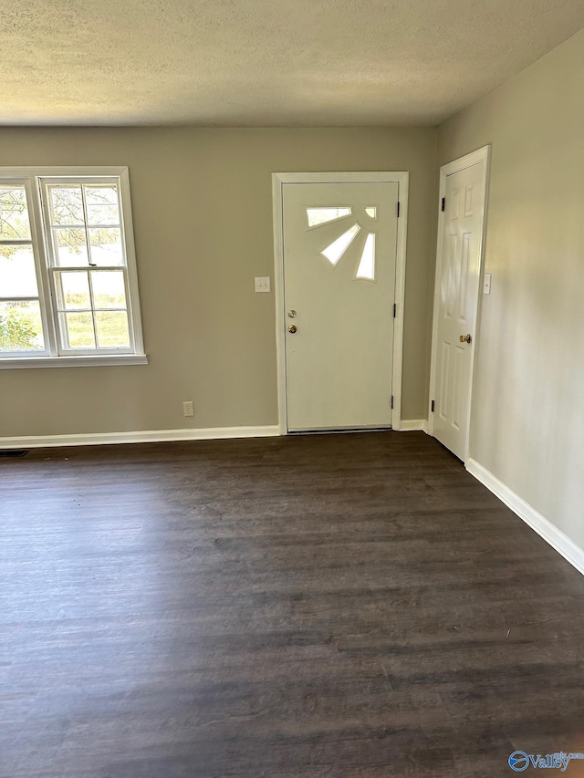 entryway featuring dark hardwood / wood-style flooring and a textured ceiling