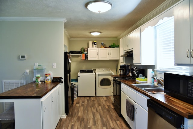 kitchen featuring under cabinet range hood, butcher block counters, separate washer and dryer, black appliances, and a sink