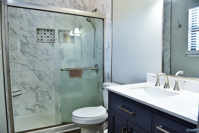 bathroom with a stall shower, toilet, and vanity