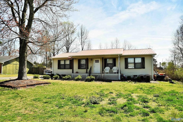 ranch-style house with metal roof, covered porch, and a front lawn