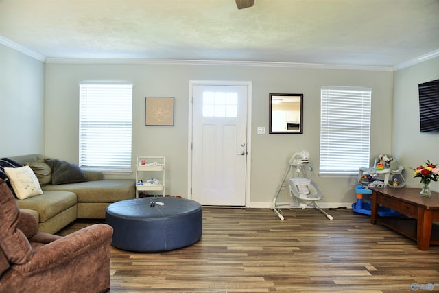 living room with crown molding, baseboards, and wood finished floors