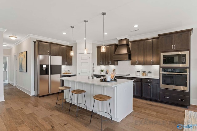 kitchen featuring stainless steel appliances, dark brown cabinetry, and custom exhaust hood