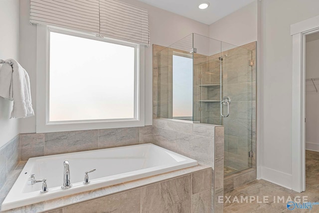 full bath with a stall shower, a spacious closet, and a garden tub