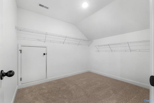 walk in closet featuring carpet floors, visible vents, and vaulted ceiling