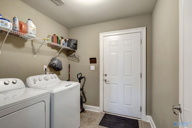 clothes washing area featuring washer and dryer and light tile patterned floors