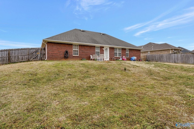 rear view of house featuring a yard